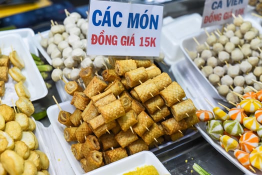 Many snacks and seafood in vietnamese night market in food festival, sign meat rolls, price 15 000 dongs photo