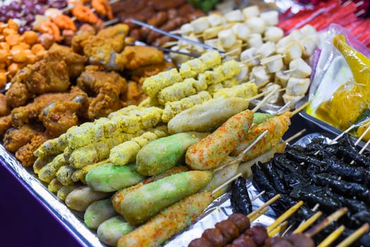 Many snacks and seafood in vietnamese night market in food festival, sign beef ball, fish ball, price 10000 dongs photo