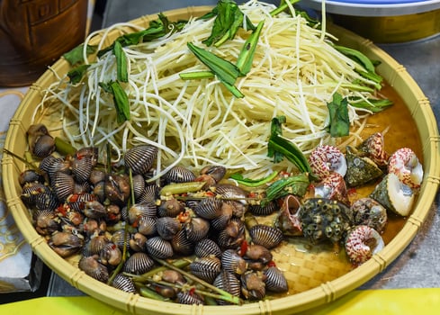 Vietnamese stewed seashell in sauce in night market on food festival photo