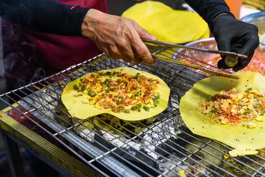 Grilled vietnamese pancake with eggs sausages and sauces in vietnamese night market in food festival photo