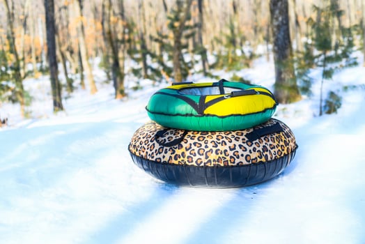 Two donuts for tubing on snow in forest without people. Winter activity photo