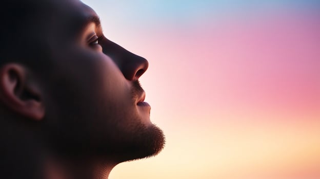 spiritual young man looking up to sky at sunrise photo