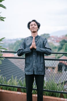 Calm young man in a thoughtful pose amidst a scenic landscape view photo