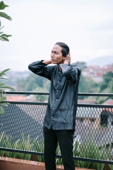 Thoughtful man gazing at distant view, on a rooftop patio photo