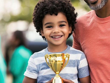 Emotional Value Concept. A smiling boy proudly holds a golden trophy, standing next to an adult, celebrating a joyful achievement outdoors. photo