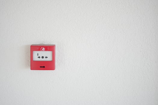 Fire alarm panel mounted on a white wall in a public building photo