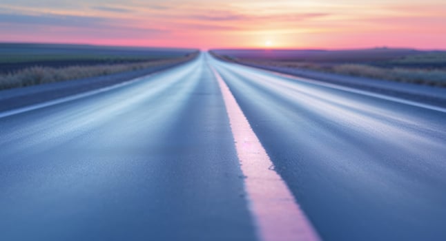 A blue highway with a sunset in the background photo