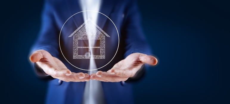Businessman holding house icon in his hands photo