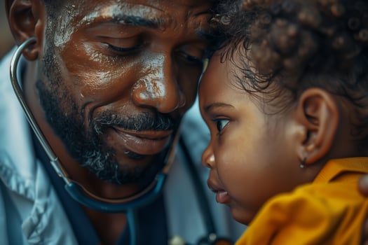 A black man with a stethoscope is holding a little girl photo