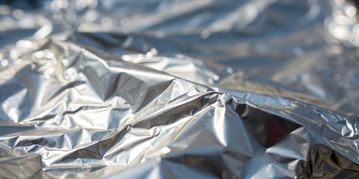 A high resolution close-up of crumpled aluminum foil, reflecting light in sharp, metallic folds photo