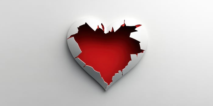 Broken heart symbol with red interior and silver border representing love and loss during a symbolic expression of emotions photo