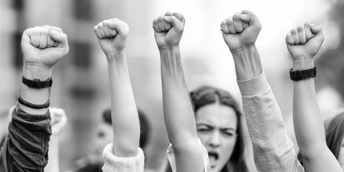 Protesters raising fists in solidarity during a demonstration. photo