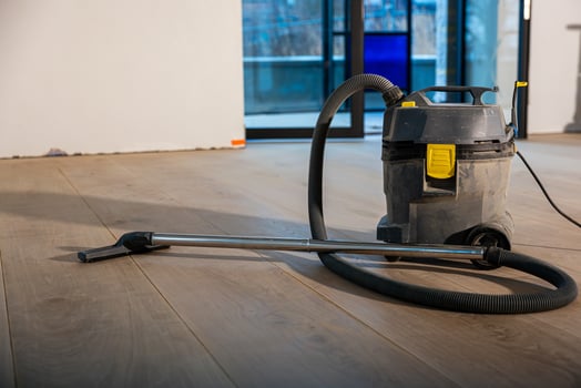 Industrial Vacuum Cleaner on Wooden Floor in Renovation Setting photo