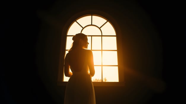 Woman Looking Through Window at Sunset with Golden Light Silhouette photo