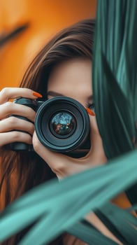 photographer with brown hair and blue eyes captures moment through camera, surrounded by lush green leaves photo