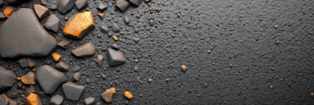 A textured surface of dark stones with orange accents. photo