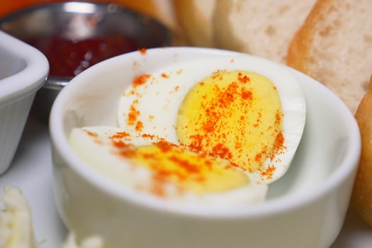 Hard boiled eggs with seasoning beside bread and condiments photo