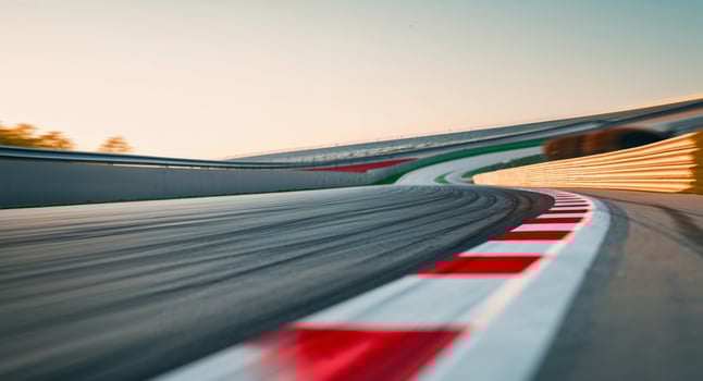 Race track curve highlighted with red and white markings during daylight. photo