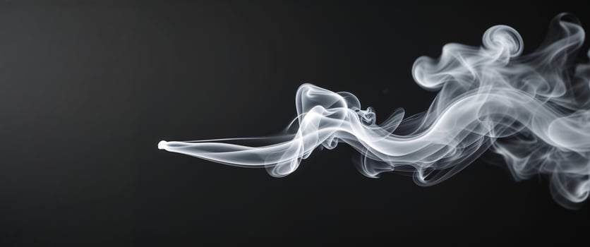 a black background with a line of white smoke photo