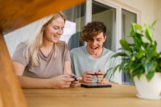 Joyful man and woman playing games on terrace. Technology and game console concept photo