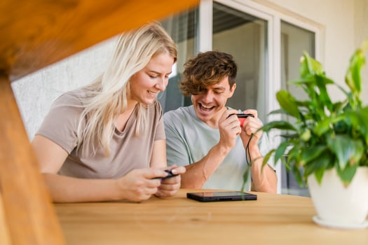 Man and woman watching a game console in a terrace in summer. Technology and game addiction concept photo