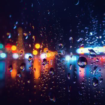 Rain droplets on window reflecting city lights at night creating dreamy urban atmosphere soft glow photo