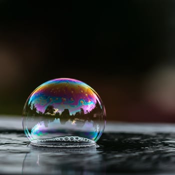 Floating soap bubble reflecting rainbow colors with water surface night background surreal magical abstract concept photo