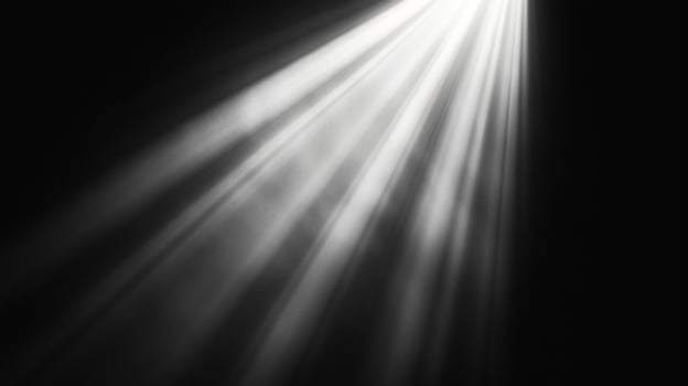 Rays of light shine dramatically from an unseen source, piercing through the darkness creating an ethereal and captivating atmosphere. photo