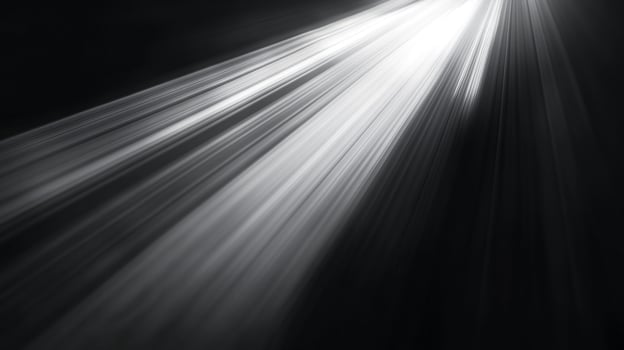 Radiant beams of light pierce through the darkness, creating a dramatic and ethereal scene. The monochromatic palette enhances the effect. photo