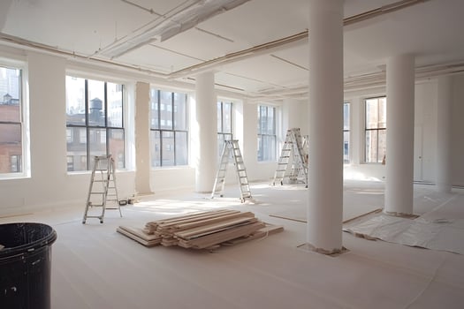 Construction workers renovating empty office space with ladders and materials photo