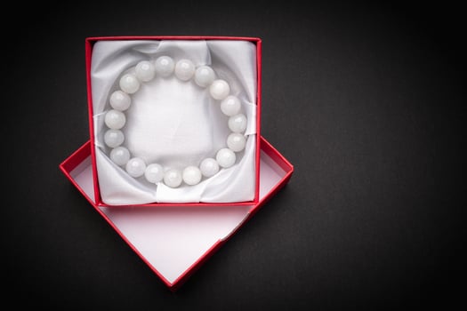 White jade bangle or bracelet in a red box on a black background photo