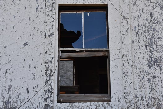 Creepy Broken Window on an Abandoned House with Peeling Paint photo