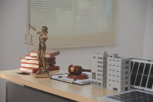 A statue of lady justice sits on a desk next to a laptop photo