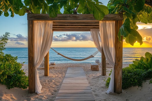 Hammock under a canopy overlooking tropical beach at sunrise photo