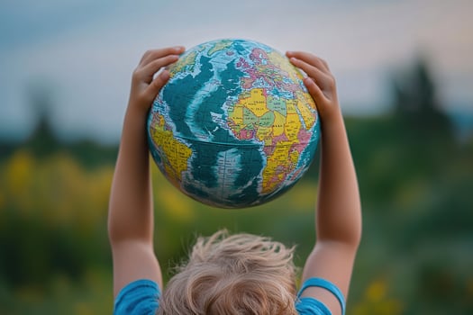 Little boy holding globe in hands on blur spring background. Earth day concept. Environmental protection photo