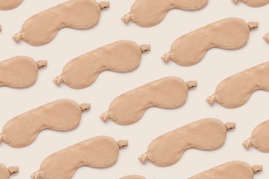 Trendy Minimal pattern from beige sleep masks on beige background, above view. Neutral colored stylish cloth eye masks for best sleeper, for travel, rest. Night time and sleep concept photo