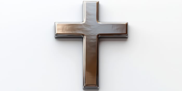 Metal cross displayed against a simple white background highlighting its reflective surface and elegant design photo