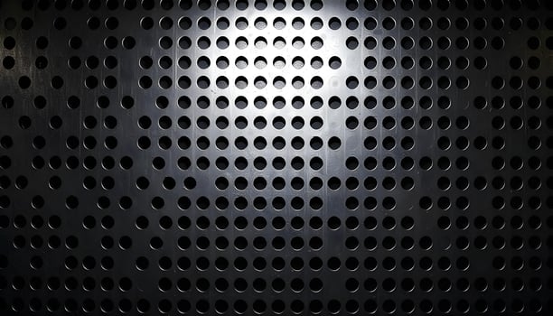Perforated metal texture with triangular holes, dark steel finish, enhanced by bright lighting photo
