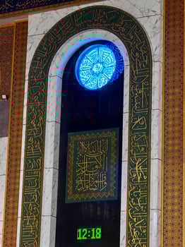 Intricate Arabic Calligraphy with Decorative Clock photo