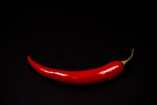 Red chili pepper on a black background showcasing vibrant color photo