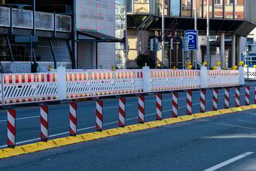 Construction barriers line the street outside a modern building photo
