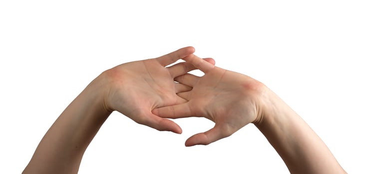 Female hands gently intertwined, fingers elegantly entwined to showcase softness, skincare, and photo