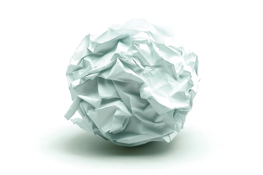 Crumpled paper ball on a plain background, symbolizing creative ideas and the writing process. photo