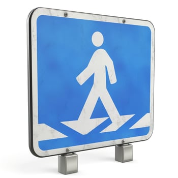 A weathered pedestrian crossing sign with a blue background, ideal for urban or safety-themed projects. photo