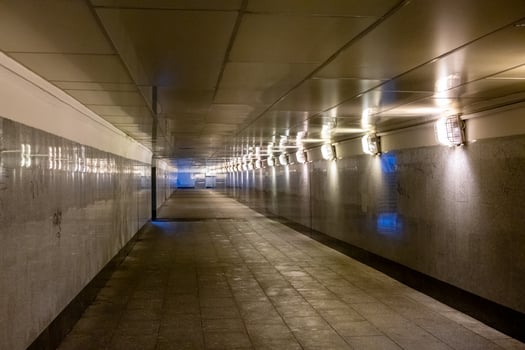 Empty underground tunnel illuminated by soft lighting in urban area at night photo