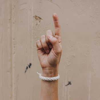 A person holding a white rope bracelet photo