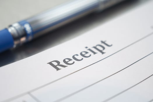 Detailed receipt on a table with a pen beside it photo