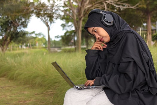 Frustrated Muslim Woman Working on Laptop in Park photo