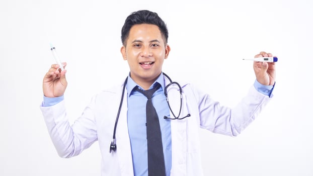 Asian Male Doctor Holding Thermometer and Syringe on White Background photo