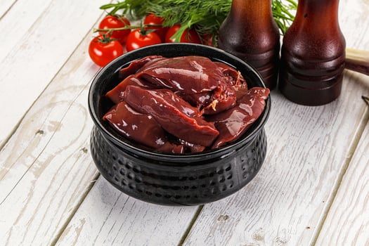 A bowl of meat and vegetables on a table photo